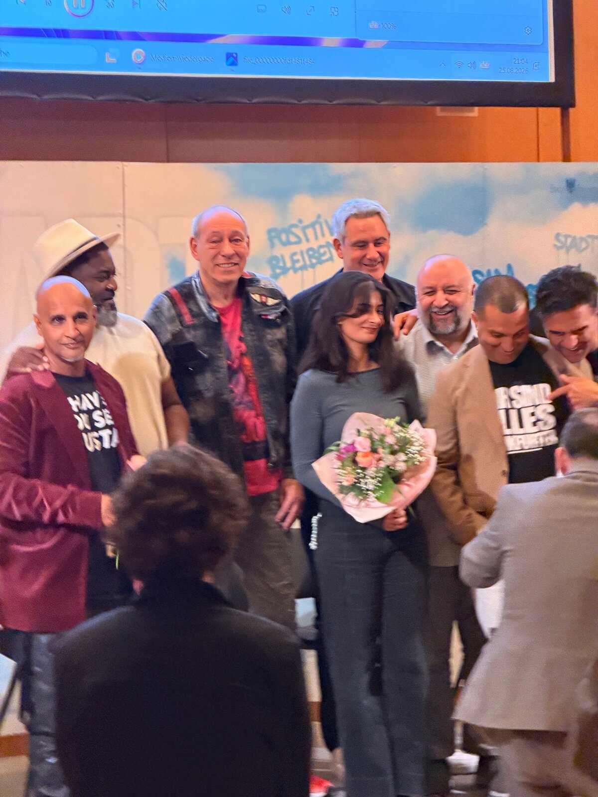 Hassan Annouri und Gäste bedanken sich mit Blumen bei einer Podiumsteilnehmerin von Stadt der Träume #5